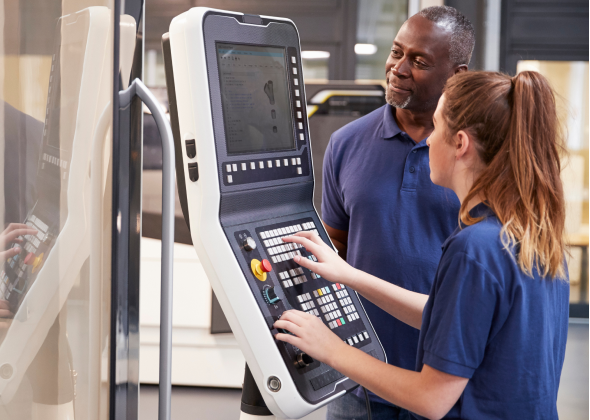 Employee woking on a control panel with a mentor